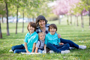 Cute children in the park with grandmother, springtime