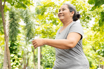 Old senior woman running, jogging, exercising in green park, breathing clean air, good and healthy life quality and wellness concept image