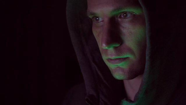 Portrait of a male hacker in a hood. nervous look. close-up.