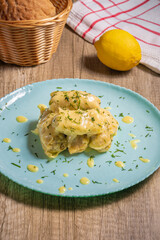 Traditional Greek cabbage rolls (Lahanodolmades) with ground beef, rice and cream sauce on a wooden table