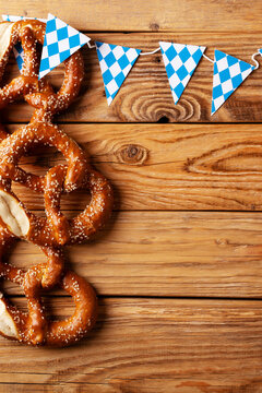 Oktoberfest concept with pretzel and blue simbol flag on wood background