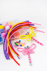 Fototapeta premium Beaded Pipe Cleaner dragonflies. Easy kids crafts. Different multi-colored supplies and materials for DIY art activity for kids. Children's crafts, creativity and hobby.