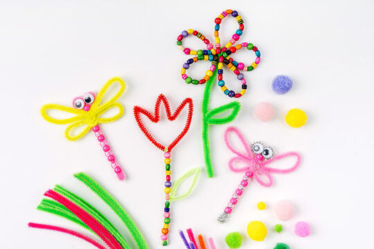 Beaded Pipe Cleaner flowers and dragonflies. Easy spring kids crafts. Different multi-colored supplies and materials for DIY art activity for kids. Children's crafts, creativity and  hobby.