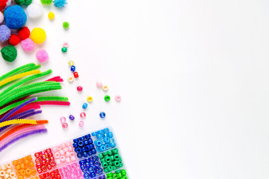 Set for children's crafts. Pipe Cleaners, beads and colorful pom-poms. Different multi-colored supplies and materials for DIY art activity for kids. Motor skills, creativity and  hobby.