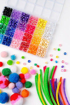 Set for children's crafts. Pipe Cleaners, beads and colorful pom-poms. Different multi-colored supplies and materials for DIY art activity for kids. Motor skills, creativity and  hobby.