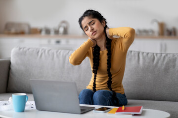 Tired Indian Woman Suffering Neck Pain While Working With Laptop At Home
