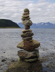 Pyramid of stones on the seashore with a view of the mountains