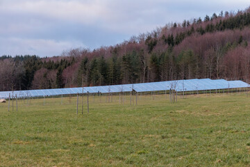 Solar park in a rural environment in front of a railroad line in Gaishaus near Ravensburg in Baden Würtemberg on a cloudy day in winter