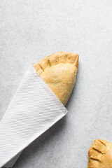Nigerian meat pie on a marble tray, freshly baked nigerian meat pie, handheld beef pies on a marble surface, nigerian small chops