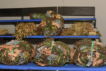 The concept of military protective equipment and camouflage cover with grass imitation. War in Ukraine. Volunteer work.