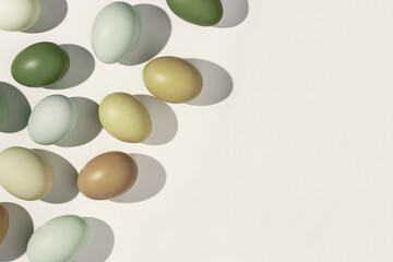 Easter eggs frame background, natural colored eggshell, hard Shadow at sunlight, beige backdrop, copy space. Chicken eggs layout, top view, minimal style flat lay, holiday food still life
