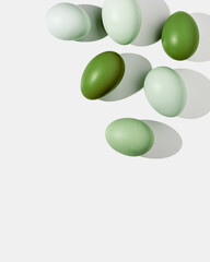 Easter eggs green gradient color with hard Shadow at sunlight, frame and light background. Chicken egg on table, top view, minimal flat lay, holiday food still life, design element, backdrop