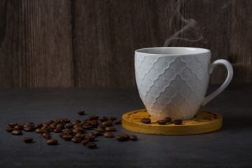 White espresso cup and coffee beans dark table background with copy space. Arabica grains, Coffee shop,