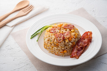 Fried Rice with Crispy Bacon.Stir fried jasmine rice with bacon carrot and egg in white plate