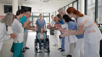 Medical staff clapping to little girl patient who recovered from serious illness. - Powered by Adobe