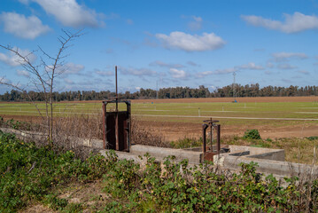 Canales de riego junto a campo de cultivo.
