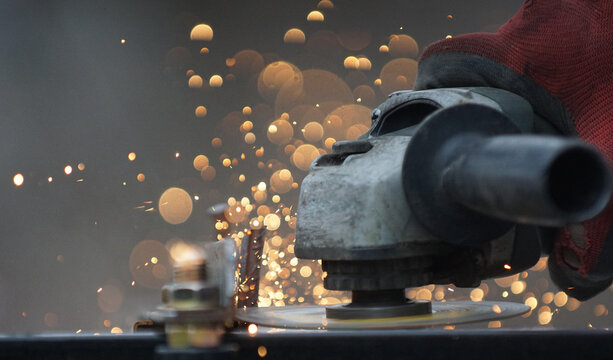 Metal processing with grinder. cutting metal on location of conctruction site, Sparks in metalworking - Powered by Adobe