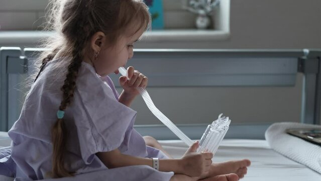 A child in the hospital uses a spirometer, rehabilitation after surgery