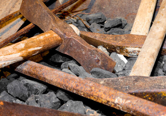hammer and other old tools over the pieces of coal in an artisanal factory where iron is worked