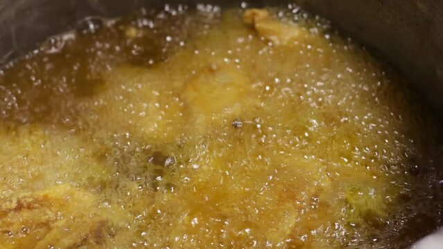 video of preparation of chicken broaster in abundant oil. Food preparation concept.