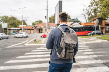 one young adult man student or tourist hold cup of coffee at crosswalk