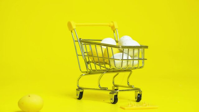 Easter Sale - Yellow and White Painted Eggs Fall Into The Shopping Cart