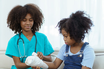 African - American black little girl have an accident at her right arm and see the doctor in hospital. Orthopedic doctor checking the splint arm of girl patient.