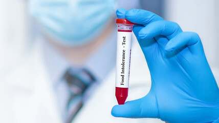 Doctor holding a test blood sample tube with food intolerance test.