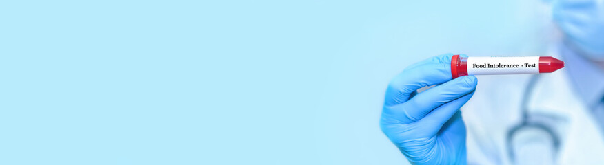 Doctor holding a test blood sample tube with food intolerance test..Banner. Copy space for text