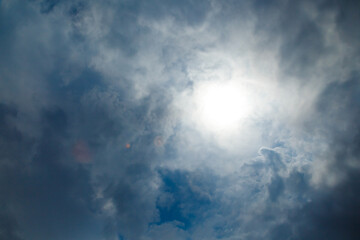 View of the calm cloudy sky through the clouds the rays break through on a summer day.