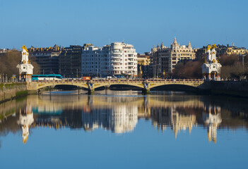 Fototapeta na wymiar Buildings of the city of Donostia-San Sebastian are reflected in the Urumea river.