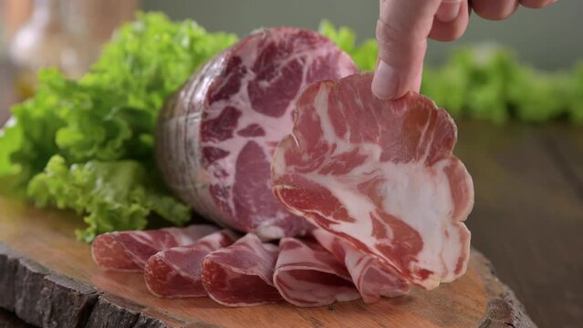 Capocollo or coppa is a traditional Italian and Corsican pork cut made from cured pork shoulder or neck. . Cut into very thin slices. Italian delicacy for aperitivo. Piacentina DOP. 4k footage
