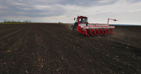 Seeding Machine Working in Field on the Farm. Agriculture. Tractor Seeder it Plants Seeds in the...