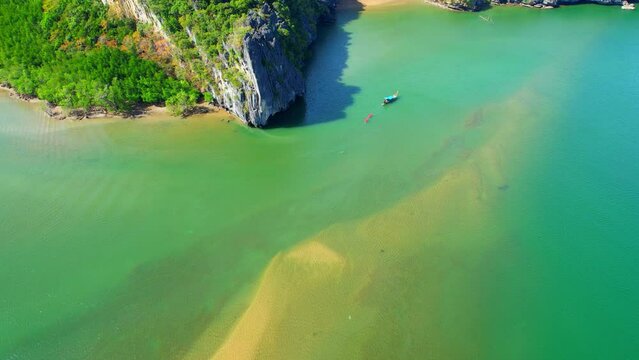 The shallow waters surrounding the sandbar are often calm and clear, making them ideal for swimming, snorkeling, or other water-based activities. (Dragon Spine Beach, Satun Province, Thailand). 4K Dro