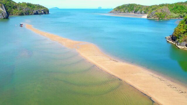A sandbar that is surrounded by crystal clear sea water in the tropical sea is a stunning natural formation. (Satun Province, Southern, Thailand). aerial view from drone. summer background. 4K UHD
