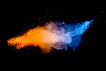 Blue  orange color powder explosion cloud on black background. Closeup of Blue  orange dust particles splash.