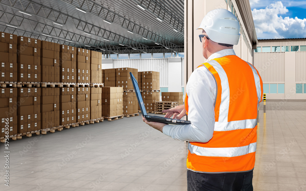 Poster man with laptop. supervisor near factory warehouse. warehouse manager with his back to camera. cardb
