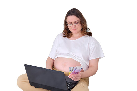 Money in the hands of a pregnant woman on the bed at home office, remote work and salary in euros, isolated on a white background