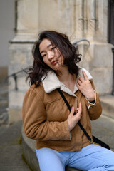 Mongolian young woman in a historic Czech city. Fashion tourist concept. 