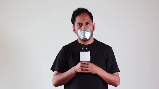 Conceptual video of Journalist with his mouth covered with tape representing censorship. Concept of journalists, media, information, media manipulation, truth.