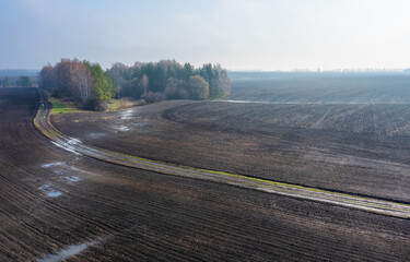Plowed agricultural fields in the early spring morning from a bird's-eye view