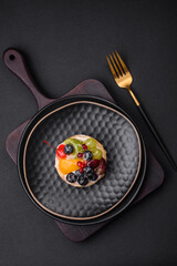 Delicious fresh tart with blueberries, cherries, grapes on a black ceramic plate