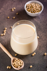 Glass of soy milk and soy beans on the table. Vegetable protein. Vertical view