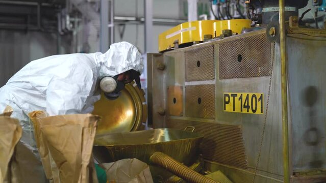 Factory worker working with production machinery at a paint factory