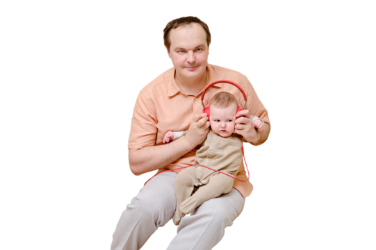 Man father and boy son listen to music on headphones on sofa in home living room, isolated on a white background. Kid aged six months