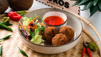 Fresh falafel balls with fresh cabbage salad, carrots, lettuce and sauce.