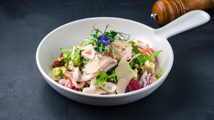 Fresh salad with chicken ham, bacon, parmesan, egg, pear, blue cheese, arugula, lettuce and walnuts.