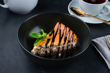 Piece of cheesecake with chocolate sauce and mint.