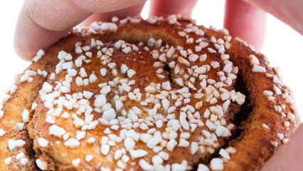 Close up of human hand about to grab a freshly baked cinnamon bun.