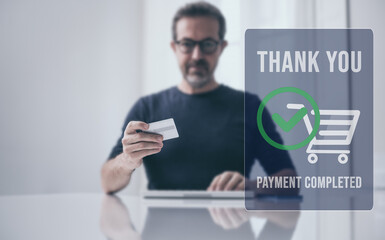 Man behind computer keyboard, purchase and pay online. Credit card in hand. Secure payment completed